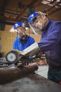 Men cutting metal with circular saw