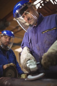 Men cutting metal with circular saw