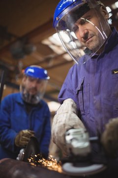 Men cutting metal with circular saw