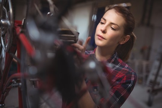 Female mechanic repairing a bicycle