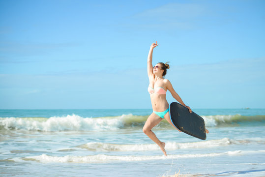 Picture of beautiful girl with bodyboard, ready for fun. Beach background