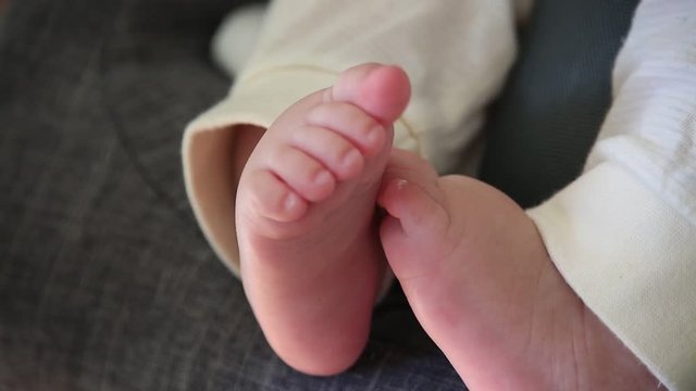 Close up shot of cute baby feet moving around while sleeping 