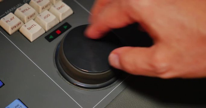 An editor searches for a shot on a videotape using an edit controller's jog/shuttle dial.
