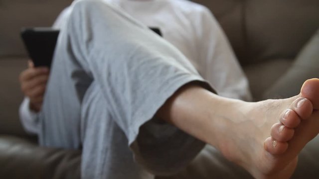 Man sitting on a sofa and using tablet pc 