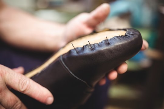 Close-up of cobbler holding a shoe