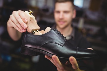 Cobbler placing shoe tree inside the shoe