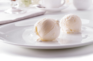 two ice cream scoops on white plate close-up 