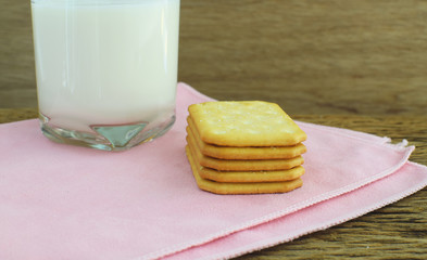 Cookies and glass of milk on rustic wooden background
