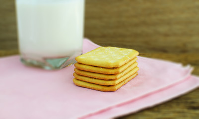 Cookies and glass of milk on rustic wooden background