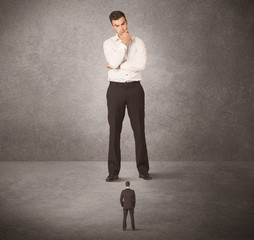 Big business man looking at small worker