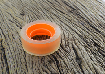 Transparent tape roll on wooden background 