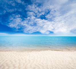 Fototapeta na wymiar Sandy Beach With Gentle Waves and Sunny Skies