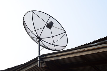 Satellite dish on top roof of wooden house, communication technology network