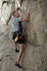 Male rock climber climbing a stone structure
