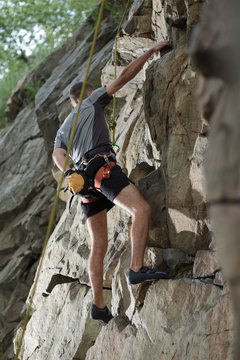 Male rock climber climbing a stone structure