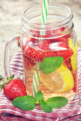 Detox Infused water with lemon, strawberry and mint on wooden background 