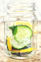 Detox Infused water with lemon, cucumber and mint on wooden background 