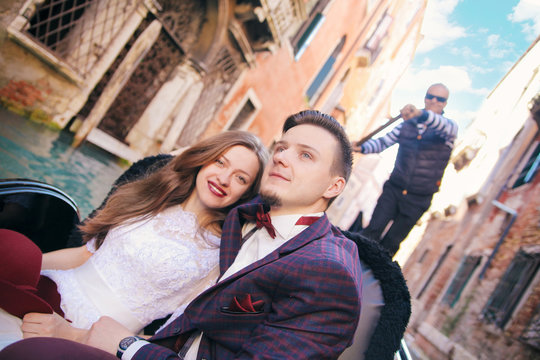 A Young Couple Riding A Gondola In Venice. Italy