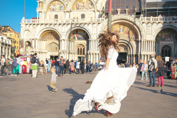 Obraz premium Young european bride is walking in Venice near the sea . Italy