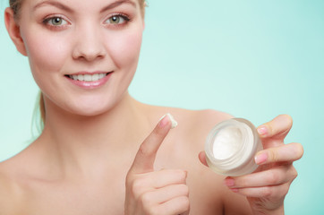 woman applying cream on her skin face.