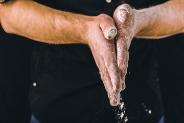 adult man hands work with flour, dark photo