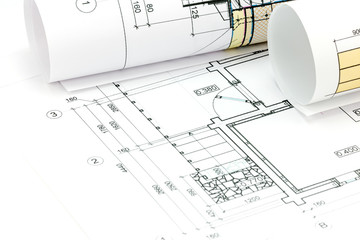 rolls of blueprints with architectural plans and technical drawi