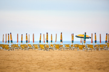 Empty sun lounges and closed parasols on the beach