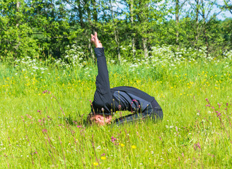 Male performs asanas on the grass.