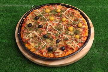Football pizza on green field