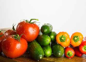 Raw vegetables on kitchen cut board, composition on white backgr
