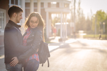 Happy moments of young couple at summer city street in evening sunlight copy space