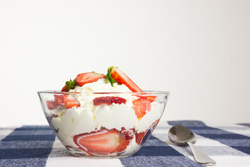 Homemade dessert with fresh strawberry and cream in a bowl on ch