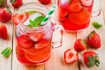 Strawberry lemonade with lime and ice in mason jar
