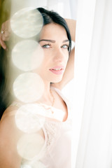 Closeup portrait of beautiful young lady looking at the window. 