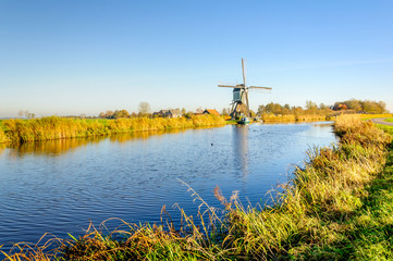 Old Dutch windmill at the bank of a canal