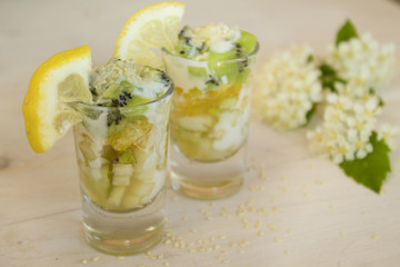 fruit, kiwi, orange and pear in small cups on a light background