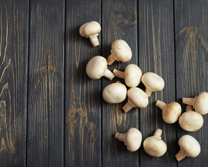 Fresh champignon mushrooms on wooden table