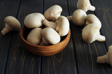 Fresh champignon mushrooms on wooden table