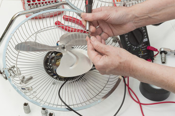 persona reparando un ventilador, motor averiado