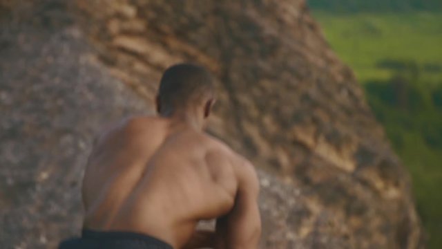 Close-up of african american bodybuilder with naked torso stretching outdoor