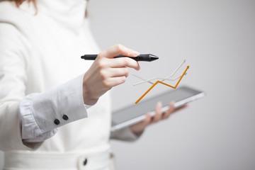 Businesswoman working with growth graph on grey background