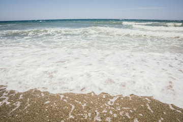 Waves, white sand beach and blue sky