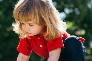 Fototapeta premium Little boy looks down