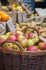 Apples in basket at fruit and vegetable market stall.