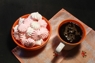 Meringue Cookies with nuts and cup of coffee on dark wooden background, top view