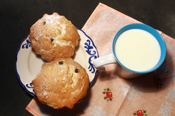 Homemade muffins and cup of milk on wooden background