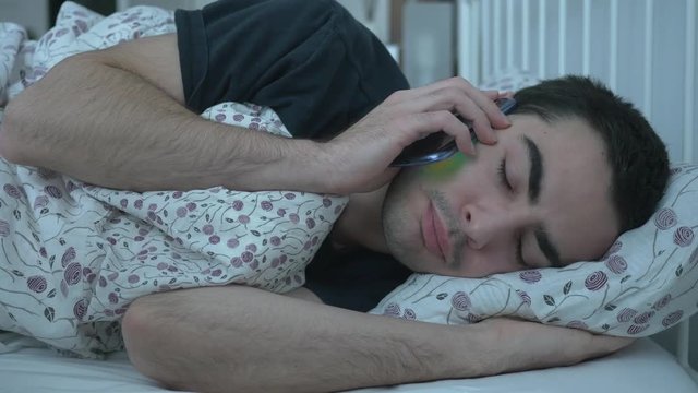Sick man coughing on the phone. He is calling his job to tell them he won't come to work today.
