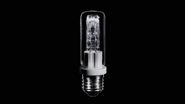 Long shaped halogen lamp blinks over black, macro with zooming video