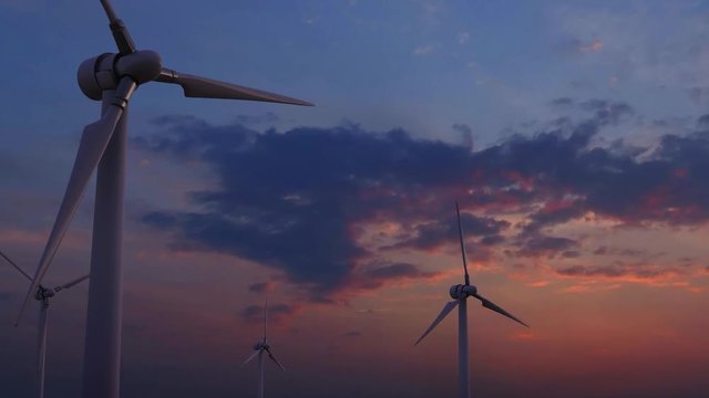 Four rotating wind generators against sunset blue and pink sky 4K dolly shot