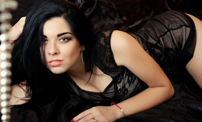 Portrait of sexy brunette with beautiful hair in black dress